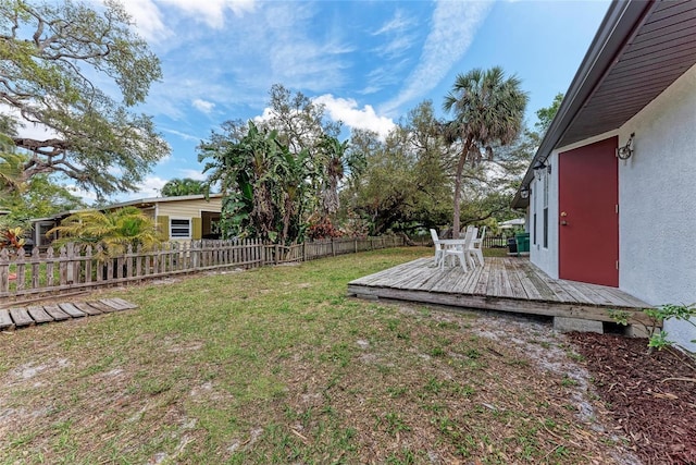 view of yard featuring fence and a deck