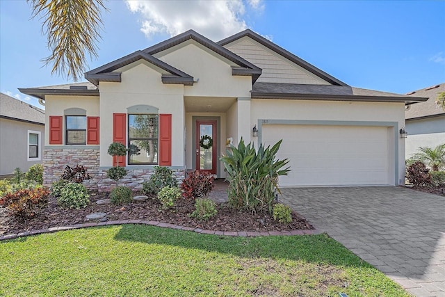 view of front of property featuring a garage, stone siding, decorative driveway, and stucco siding