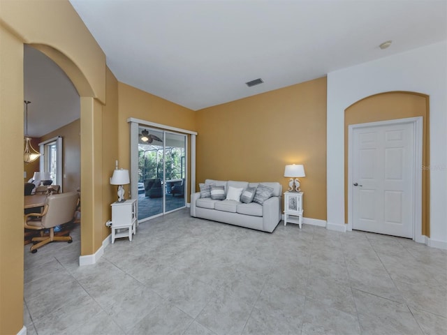 living room featuring baseboards, visible vents, and arched walkways