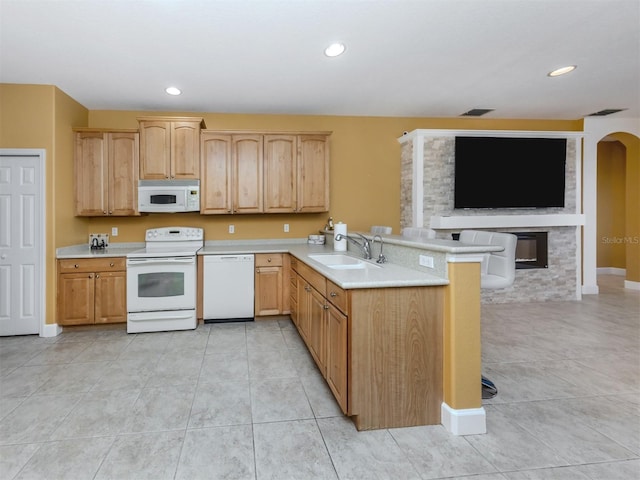 kitchen with white appliances, arched walkways, light countertops, and a sink