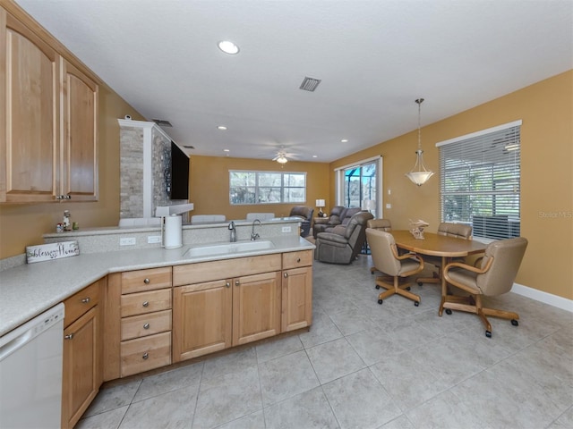 kitchen featuring visible vents, dishwasher, a peninsula, light countertops, and a sink