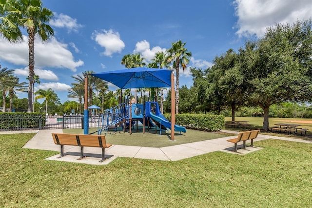 community jungle gym featuring a yard and fence