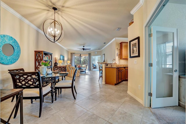 dining area featuring light tile patterned floors, ceiling fan with notable chandelier, visible vents, baseboards, and crown molding