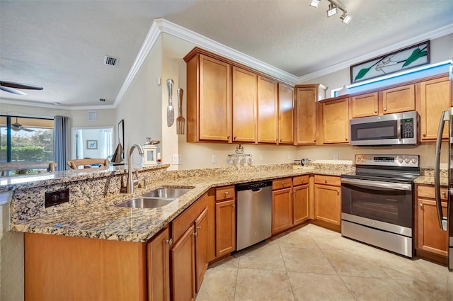 kitchen with ceiling fan, stainless steel appliances, a sink, visible vents, and brown cabinetry