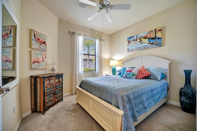 bedroom with light carpet, ceiling fan, a textured ceiling, and baseboards