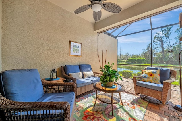 sunroom featuring a water view and ceiling fan