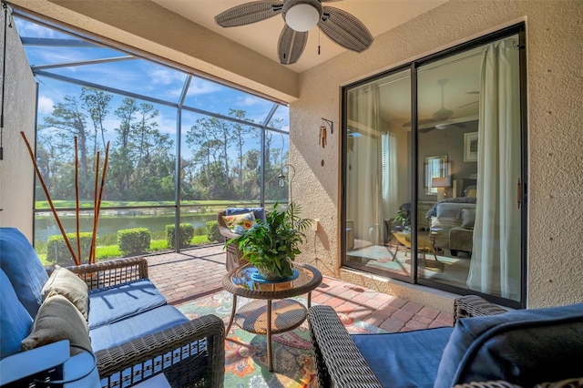 sunroom with a water view and a ceiling fan