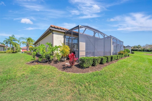 view of property exterior with a lanai, stucco siding, a lawn, and a tiled roof