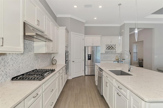 kitchen with under cabinet range hood, stainless steel appliances, a sink, white cabinets, and a center island with sink