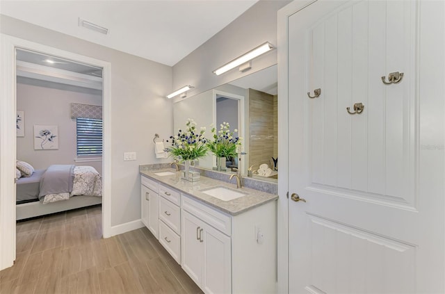 bathroom with visible vents, a sink, ensuite bath, and double vanity