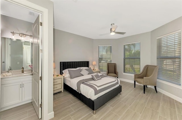 bedroom featuring connected bathroom, a sink, a ceiling fan, visible vents, and baseboards