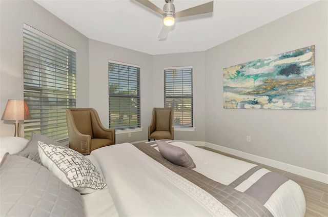 bedroom featuring ceiling fan, baseboards, and wood finished floors