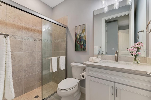 bathroom featuring vanity, a shower stall, and toilet