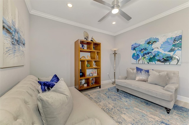 living room featuring baseboards, wood finished floors, a ceiling fan, and crown molding