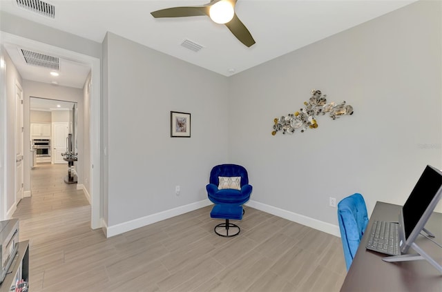 office area with visible vents, light wood-style flooring, and baseboards