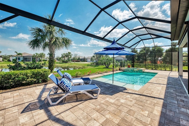 view of pool with glass enclosure, a pool with connected hot tub, a patio area, and a water view