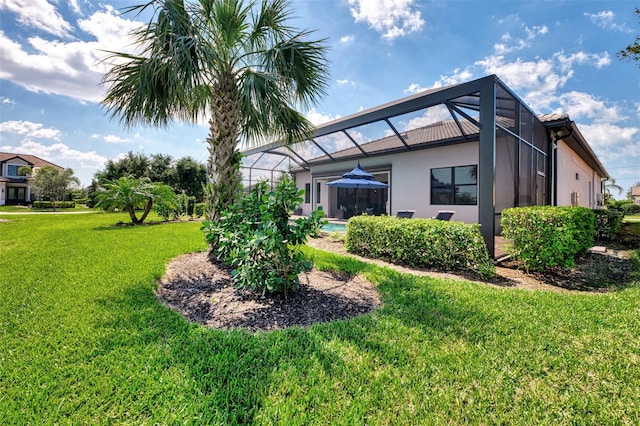 rear view of property featuring a lanai, an outdoor pool, a lawn, and stucco siding