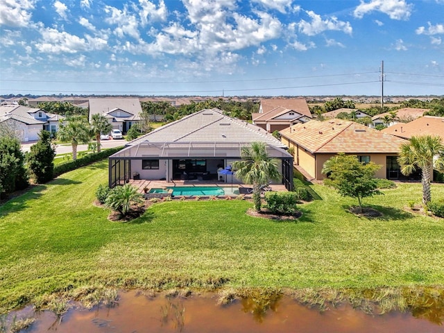 rear view of property with a lanai, an outdoor pool, a yard, a residential view, and stucco siding