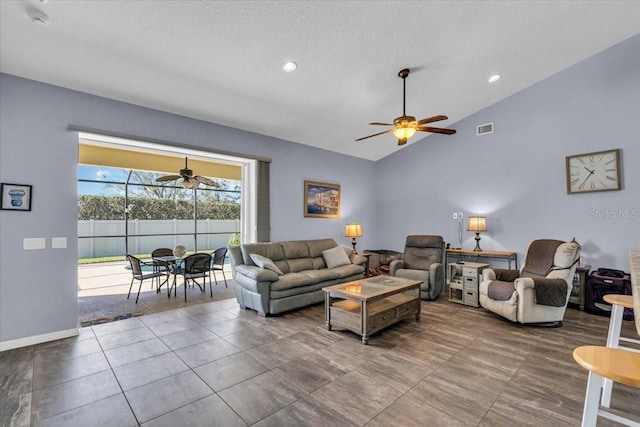 living room featuring lofted ceiling, visible vents, ceiling fan, and a textured ceiling