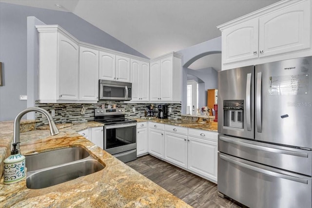 kitchen with lofted ceiling, backsplash, stainless steel appliances, and a sink