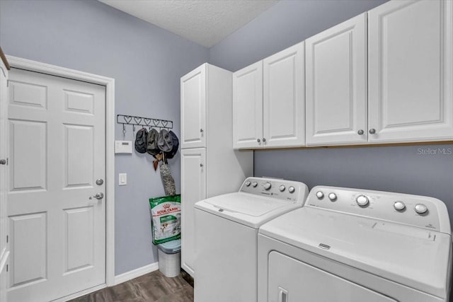 clothes washing area with dark wood finished floors, cabinet space, a textured ceiling, separate washer and dryer, and baseboards