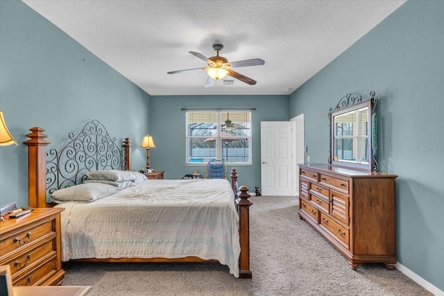 carpeted bedroom with ceiling fan, baseboards, and a textured ceiling