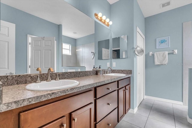 bathroom with tile patterned flooring, visible vents, a sink, and tiled shower