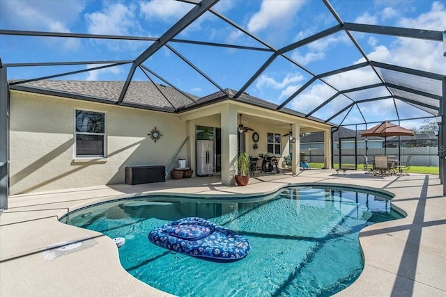 view of pool with a patio, glass enclosure, fence, a fenced in pool, and outdoor dining space