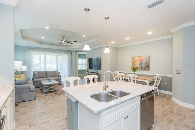 kitchen with visible vents, stainless steel dishwasher, light wood-style floors, open floor plan, and a sink