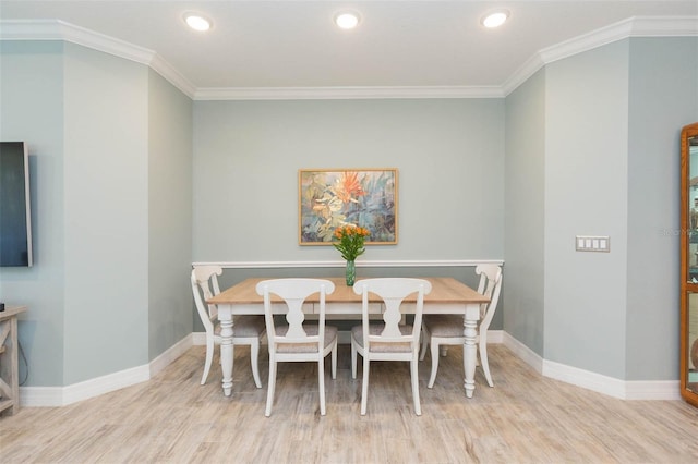 dining area featuring ornamental molding, baseboards, and wood finished floors