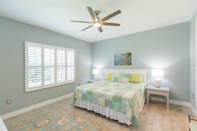 bedroom featuring ceiling fan, baseboards, and wood finished floors