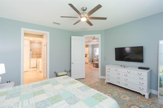 bedroom featuring a ceiling fan, visible vents, baseboards, and wood finished floors