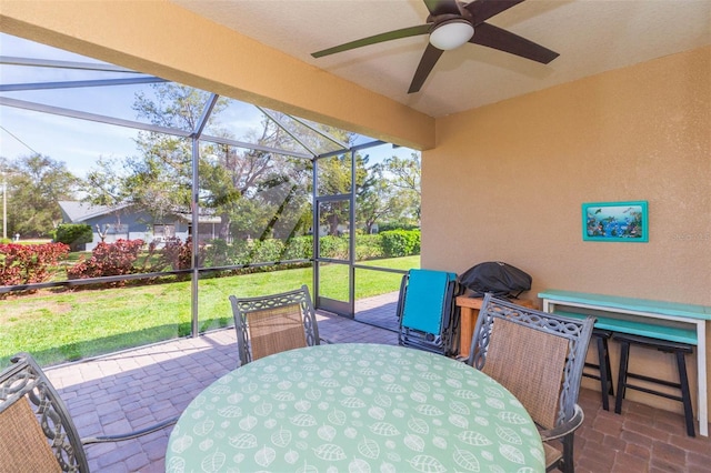 view of patio featuring a lanai, ceiling fan, and outdoor dining space