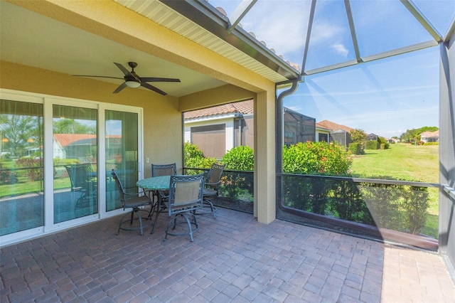 unfurnished sunroom featuring ceiling fan