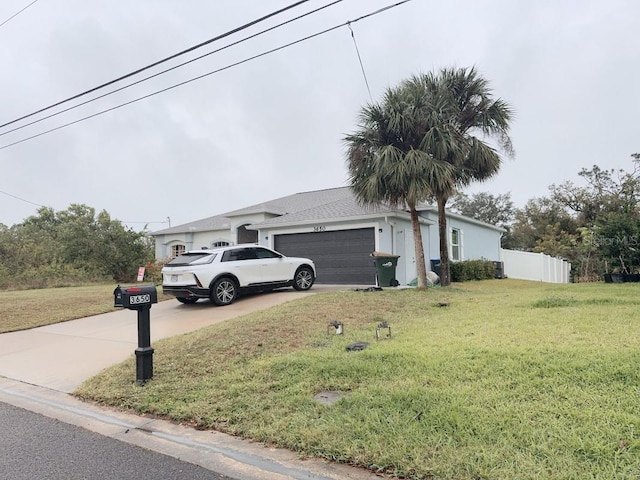 view of front of home with driveway, a garage, fence, and a front yard