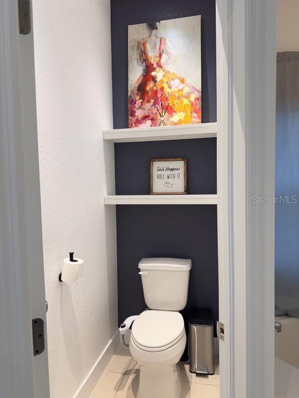 bathroom featuring baseboards, toilet, and tile patterned floors