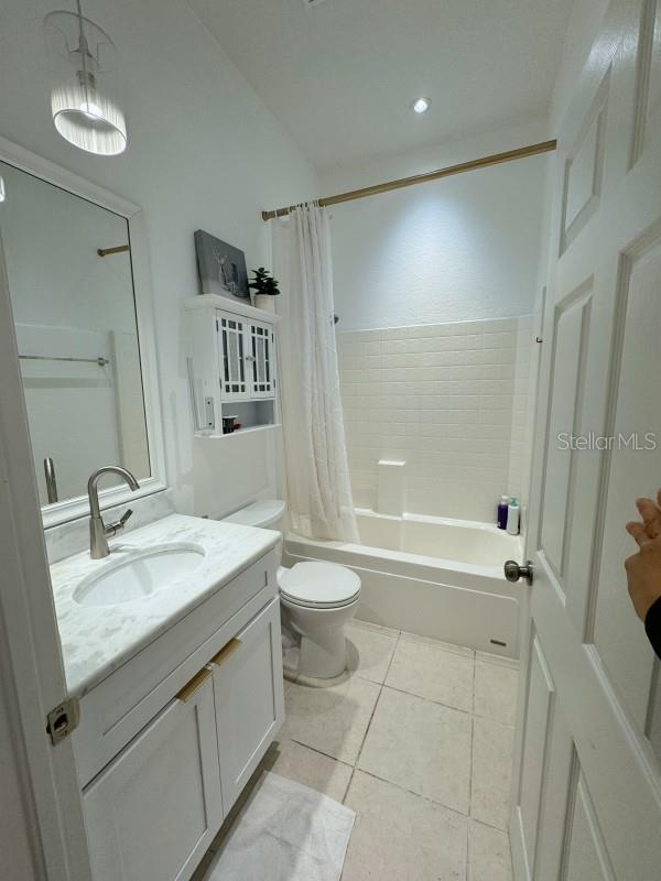 3650 S Sumter Blvd, North Port, FL 34287 - full bathroom featuring tile patterned floors, shower / bath combination with curtain, toilet, and vanity