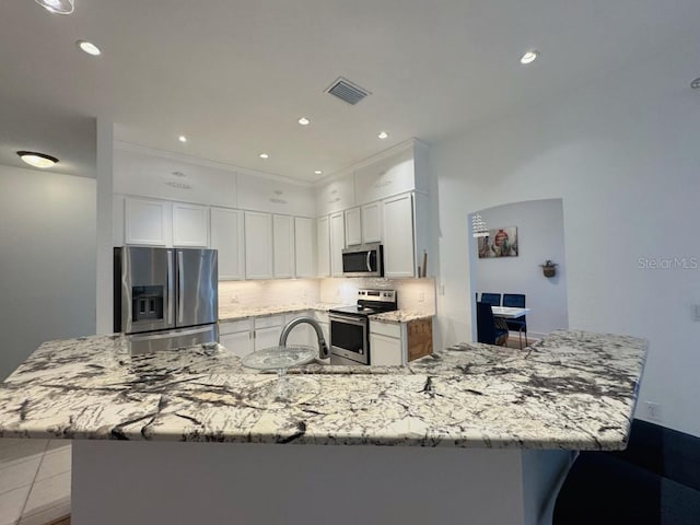 3650 S Sumter Blvd, North Port, FL 34287 - kitchen with stainless steel appliances, backsplash, light stone counters, a large island, and white cabinets