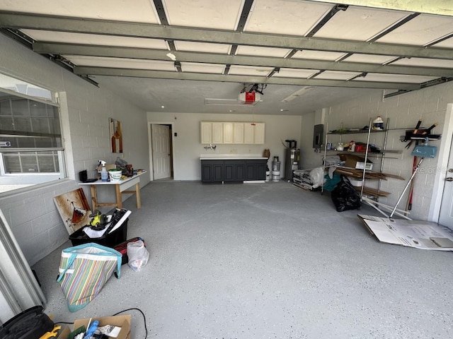 3650 S Sumter Blvd, North Port, FL 34287 - garage with electric panel, water heater, concrete block wall, and a garage door opener