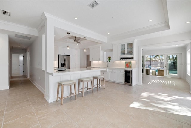 kitchen with beverage cooler, visible vents, a breakfast bar area, and stainless steel refrigerator with ice dispenser