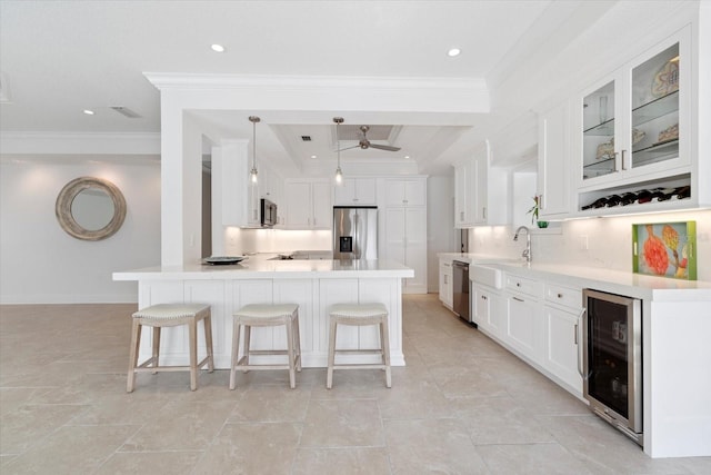 kitchen featuring glass insert cabinets, wine cooler, a breakfast bar area, ornamental molding, and appliances with stainless steel finishes