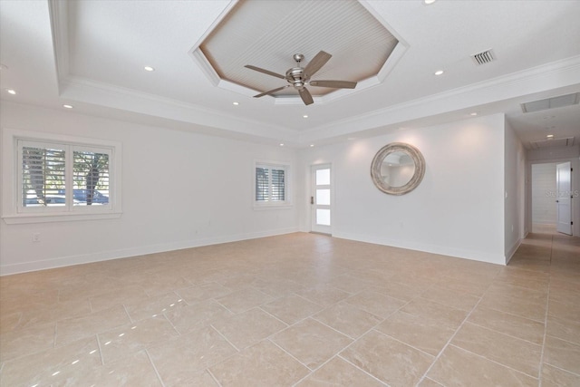 unfurnished room with a wealth of natural light, visible vents, a tray ceiling, and ornamental molding