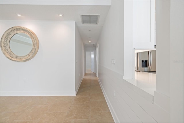 hall featuring baseboards, visible vents, attic access, light tile patterned flooring, and recessed lighting