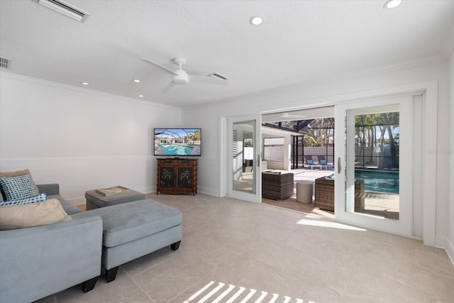 living area featuring visible vents, ceiling fan, and ornamental molding