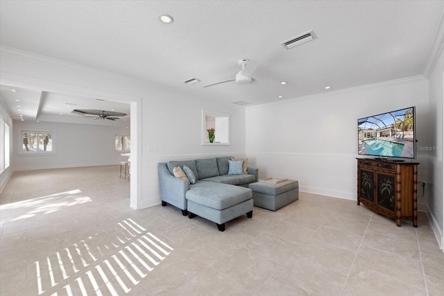 living area featuring visible vents, ceiling fan, and crown molding