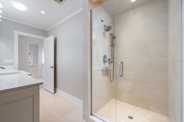 bathroom featuring vanity, crown molding, baseboards, and a stall shower