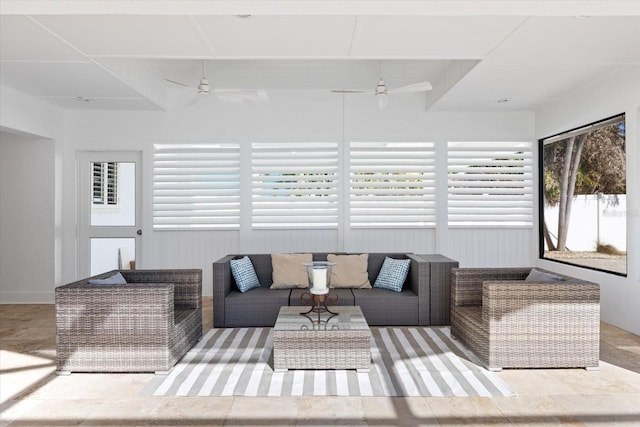 living area with ceiling fan and a sunroom