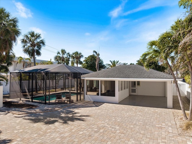 rear view of property with fence, a fenced in pool, stucco siding, a lanai, and a patio area