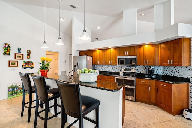 kitchen with high vaulted ceiling, a kitchen bar, appliances with stainless steel finishes, and backsplash