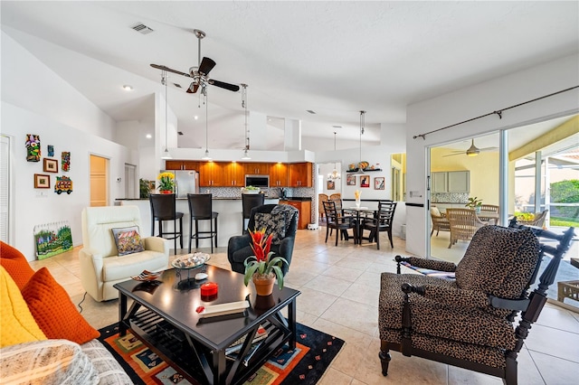 living area with high vaulted ceiling, light tile patterned flooring, visible vents, and a ceiling fan